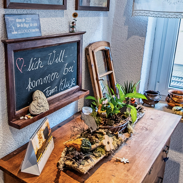 Empfangsbereich – Pension Kluge Freiberg Willkommensbereich der Pension Kluge in Freiberg mit liebevoller Dekoration und Tafel „Herzlich willkommen“.