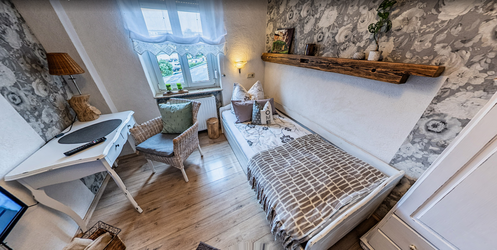 Einzelzimmer der Pension Kluge in Freiberg mit hellem Fenster, Schreibtisch und liebevoller Einrichtung.